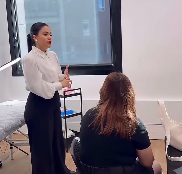 Giovanna Medeiros de camisa branca, dando aula para uma turma em Paris