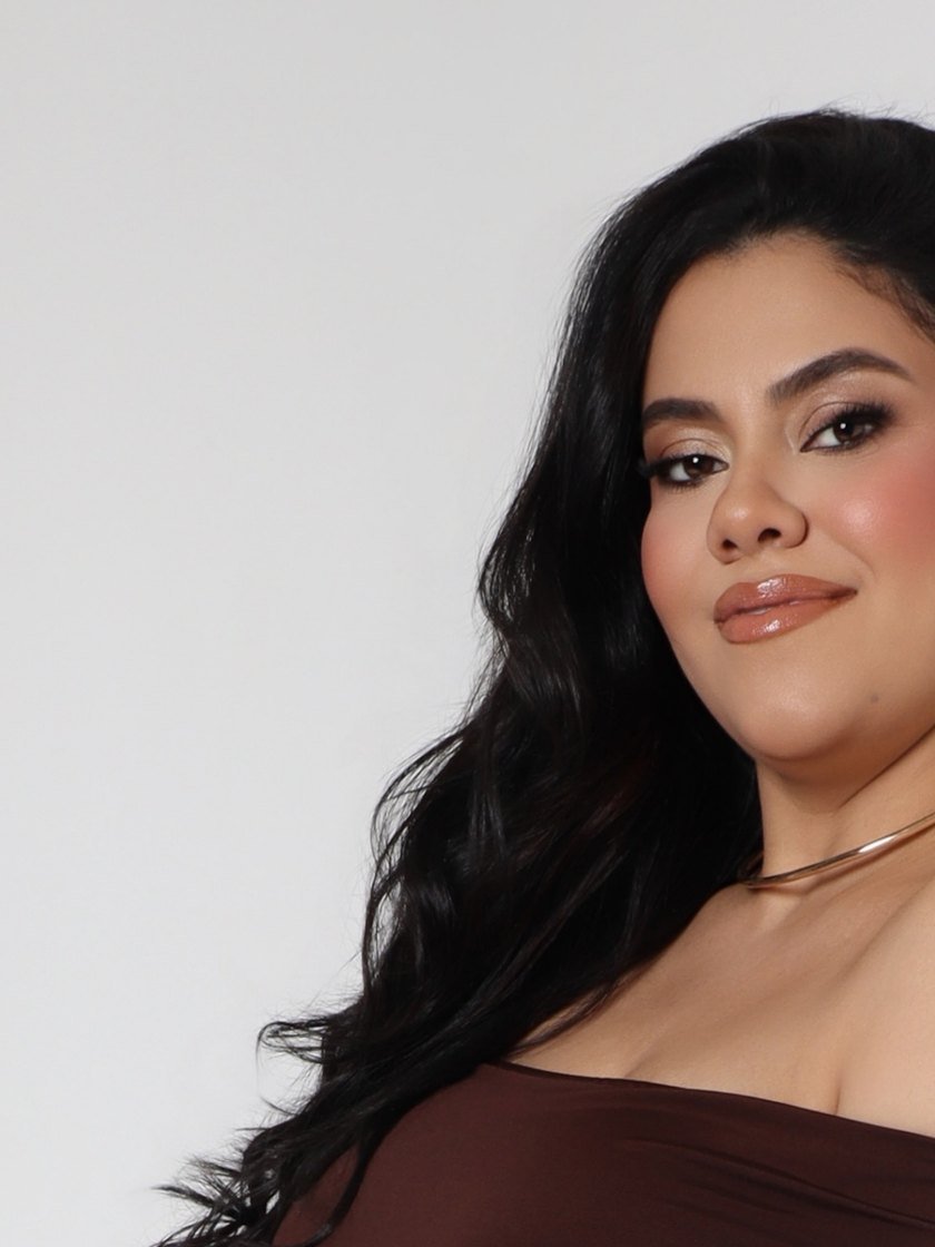 Giovanna Medeiros de vestido marrom, sorrindo, com o cabelo solto